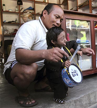 Thapa and his father Rup Bahadur Thapa play with a birthday gift given to Khagendra at his rented house in Pokhara