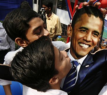 Students reach out to kiss a cutout of Obama at the American Centre in New Delhi