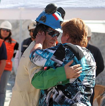 Trapped miner Johnny Barrios hugs his girlfriend Susana Valenzuela after reaching the surface to become the 21st to be rescued from the San Jose mine in Copiapo