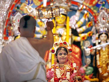 A priest worships a girl dressed as goddess Durga on Kumari Puja, one of the biggest attractions of the festival