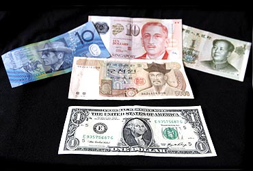 A US dollar note is pictured alongside other currencies including the Australian Dollar, Singapore Dollar, Korean Won and China's Yuan