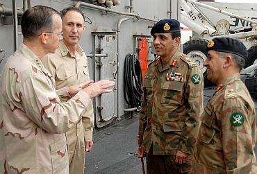 (From Left) US Navy Adm Mike Mullen, chairman of the Joint Chiefs of Staff, and US Navy Rear Adm Scott Van Buskirk, commander of Carrier Strike Group 9, talk with Pakistani Army Gen Ashfaq Kayani, chief of army staff, and Pakistani Army Major Gen Ahmad Shuja Pasha, director general of military operations, on the flight deck aboard USS Abraham Lincoln in the North Arabian Sea