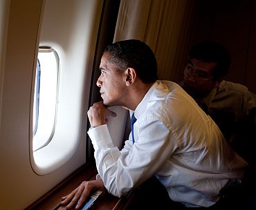 President Barack Obama looks out a window at Mount St Helens and Mount Rainier during a flight aboard Air Force One from Los Angeles to Seattle