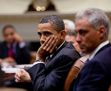 Obama with Chief of Staff Rahm Emanuel (right) listens during an economic briefing in the Roosevelt Room of the White House