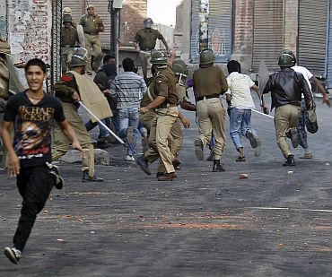 Police chase away Kashmiri protesters during an anti-India protest in Srinagar on October 15. At least 110 people have been killed since June, mostly by police bullets. The protests are the biggest since an armed revolt against Indian rule broke out in Kashmir in 1989