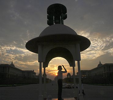 A traffic police woman directs traffic as she is silhouetted against the backdrop of clouds during an evening in New Delhi