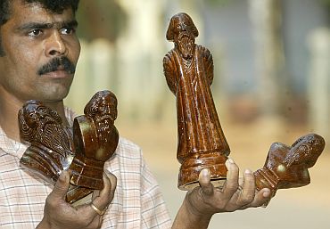 : A street seller hawks clay models of Rabindranath Tagore near a museum in Shaniniketan