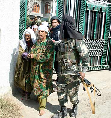 A soldier escorts civilians to safety during the gunbattle