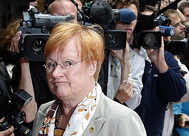 Journalists click photographs as Finland's President Halonen arrives at a EU summit