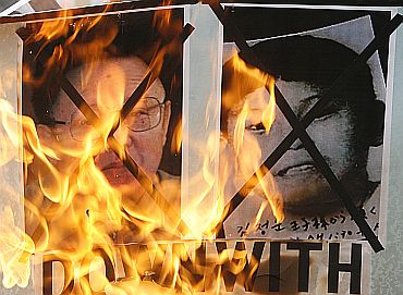 Protesters in Seouol burn portraits of North Korean leader Kim Jong-il and his son during a demonstration demanding the release of two US journalists held in North Korea