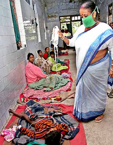 An medic tends to a child afflicted with malaria at a hospital in Siliguri, West Bengal