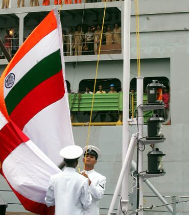 Engineers and dock labours watch commissioning ceremony of Indian guided missile frigate warship in Kolkata