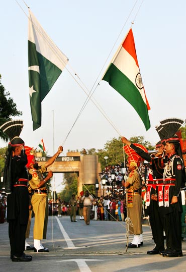 Pakistani Rangers and BSF jawans lower their respective country flags during the daily parade at Wagah border