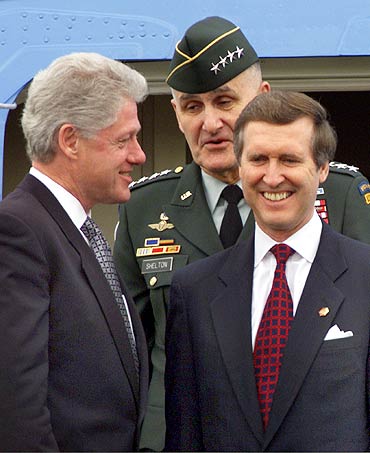 US President Bill Clinton with General Hugh Shelton, Commander of the Joint Chiefs of Staff and Secretary of Defense William Cohen (R) upon their arrival at the Norfolk Naval Base