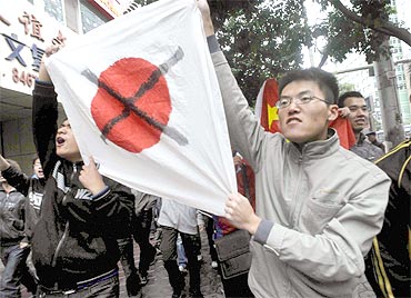 Chinese students hold a defaced Japanese national flag during their anti-Japan demonstration in Lanzhou in Gansu province