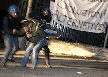 Riot policemen arrest a protester during violent overnight protests against the opening of a new waste dump in Terzigno