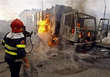 Firemen extinguish a burning truck after violent protests against the opening of a new waste dump in Terzigno