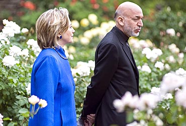 Karzai and US Secretary of State Hillary Clinton talk while walking in a private Georgetown garden in Washington