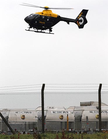 A police helicopter hovers over UPS containers at East Midlands Airport in Castle Donington, central England