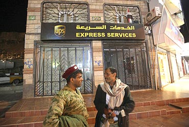 A soldier talks to a man in front of the UPS office in Sanaa, Yemen
