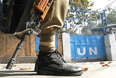 A policeman guards the main gate of the United Nations Military Observer Group during a curfew in Srinagar