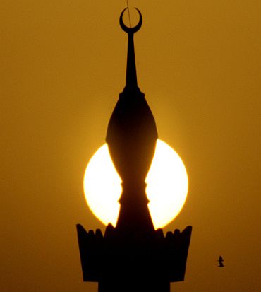 The sun sets behind a minaret in the centre of Riyadh