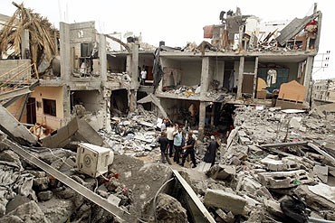 Palestinians survey houses damaged in an explosion in the central Gaza Strip