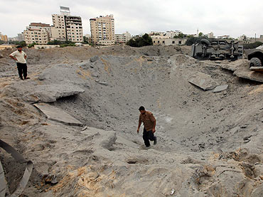 A member of Hamas' security forces surveys the damage after Israeli air strikes