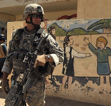 US Army Sgt David Diehl, from Alpha Company, 1st Battalion, 21st Infantry Regiment, provides security outside a school in Baqubah, Iraq