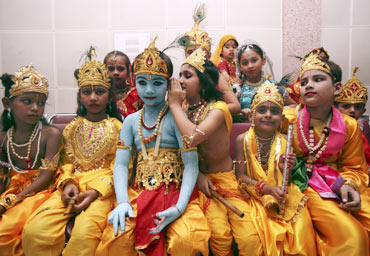 Children dressed as  Lord Krishna wait for a fancy dress competition