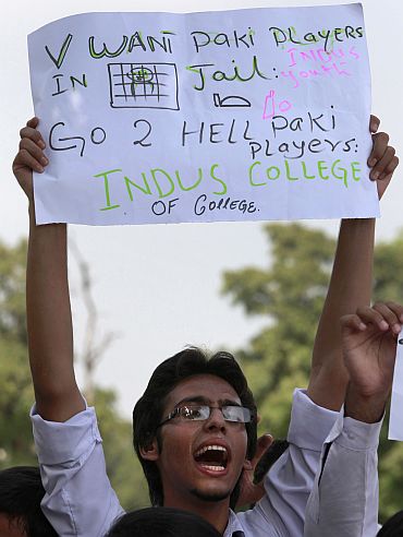 A Pakistani student holds a placard as he shouts slogans against national cricket team players who are involved in a match fixing scandal, during a protest in Islamabad