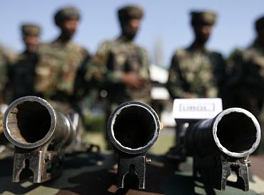 Army soldiers stand behind seized a display of under barrel grenade launchers (UBGL) during a news conference in a garrison in Srinagar