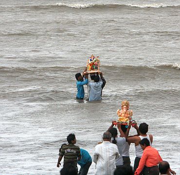 People immersing Ganesh idols in the sea