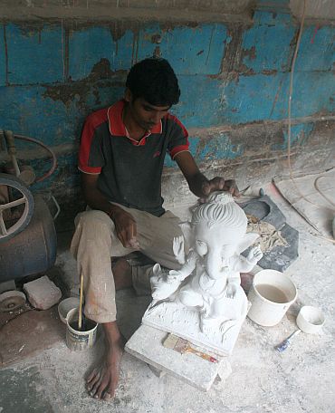 A worker creates a Ganesh idol using PoP