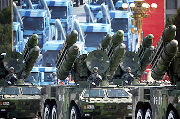 People's Liberation Army rocket launcher trucks rumble past Tiananmen Square