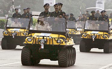 Policemen on amphibious vehicles attend a parade in Mumbai November 26, 2009