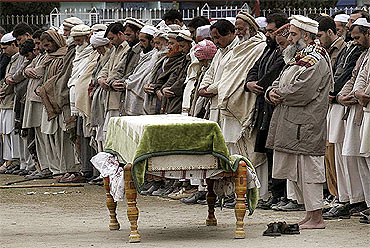 Men line-up for the funeral prayer of a victim who was killed during an attack on the Lankan team