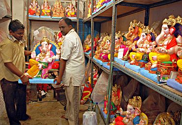 Shopkeepers stocking up ready Ganesha idols in a workshop