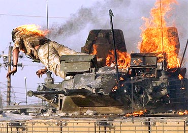 A British soldier jumps from a burning tank which was set ablaze after a shooting incident in the southern Iraqi city of Basra on September 19, 2005