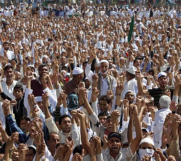 Kashmiris raise their hands while chanting anti-India slogans during an anti-India protest in Srinagar