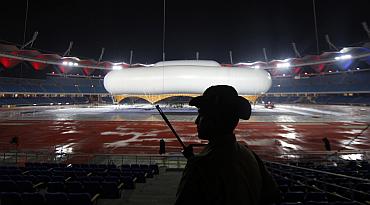 A guard keeps watch over the giant aerostat inside the Jawaharlal Nehru stadium in New Delhi