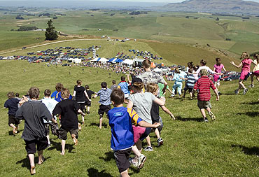 Competitors participate in a race at the Whitestone Cheese Rolling contest in New Zealand