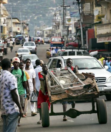 A Sierra Leonian man pushes a handcart in downtown Freetown
