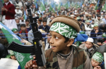 A boy holds a toy gun during an anti-India rally