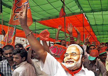 A BJP supporter wearing a mask of Gujarat CM Narendra Modi at a rally in Delhi