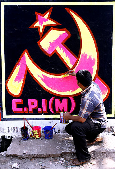 A CPM worker paints his party's symbol on a wall in Siliguri