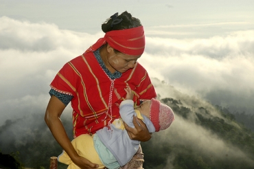 Ma Sun breastfeeds her nine-month-old son standing atop Golden Rock