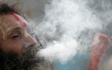 A sadhu smokes marijuana in Allahabad