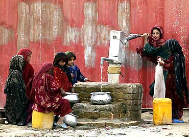 Afghan women collect drinking water from a handpump in a village near Kabul.