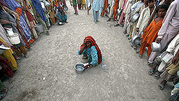 A flood victim waits for food handouts at a relief camp in Sukkur in Pakistan's Sindh province